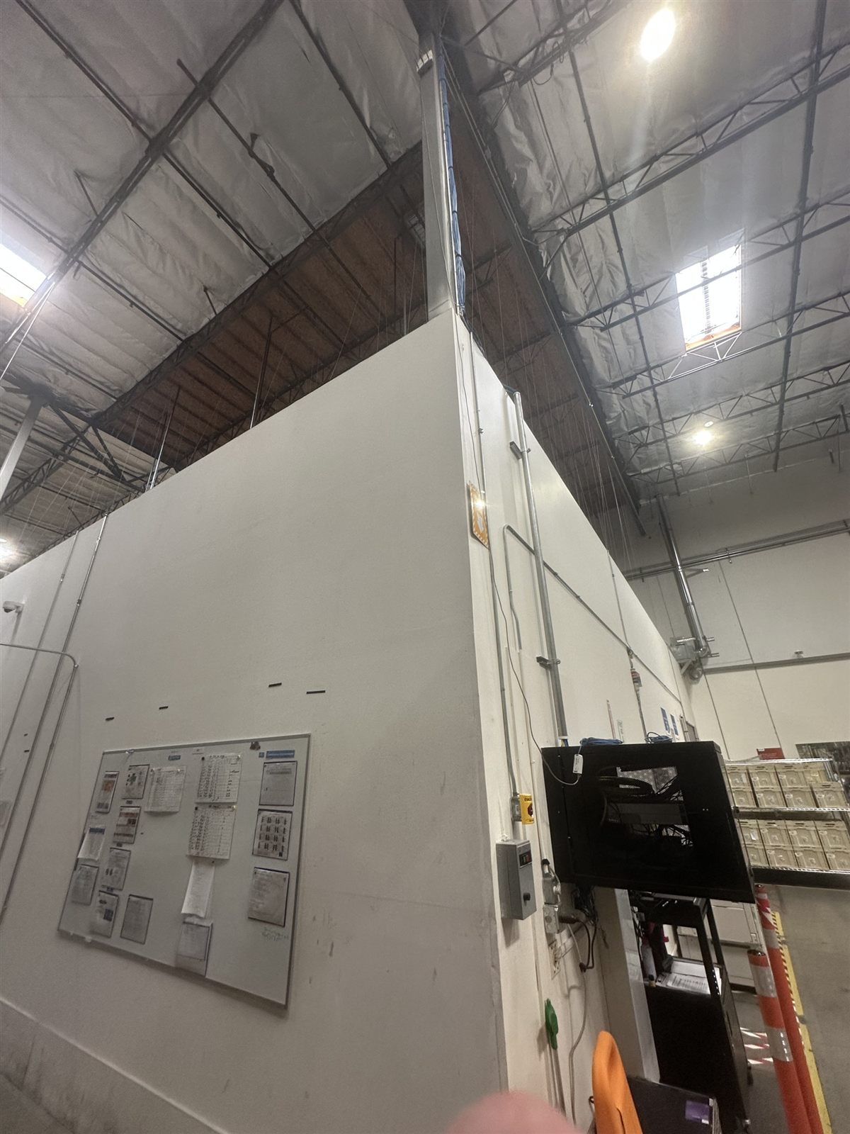 Temporary dust-containment wall inside a clear-span warehouse during interior demolition