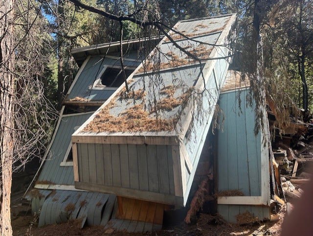 Fire-damaged A-frame cabin before demolition in Crestline, CA
